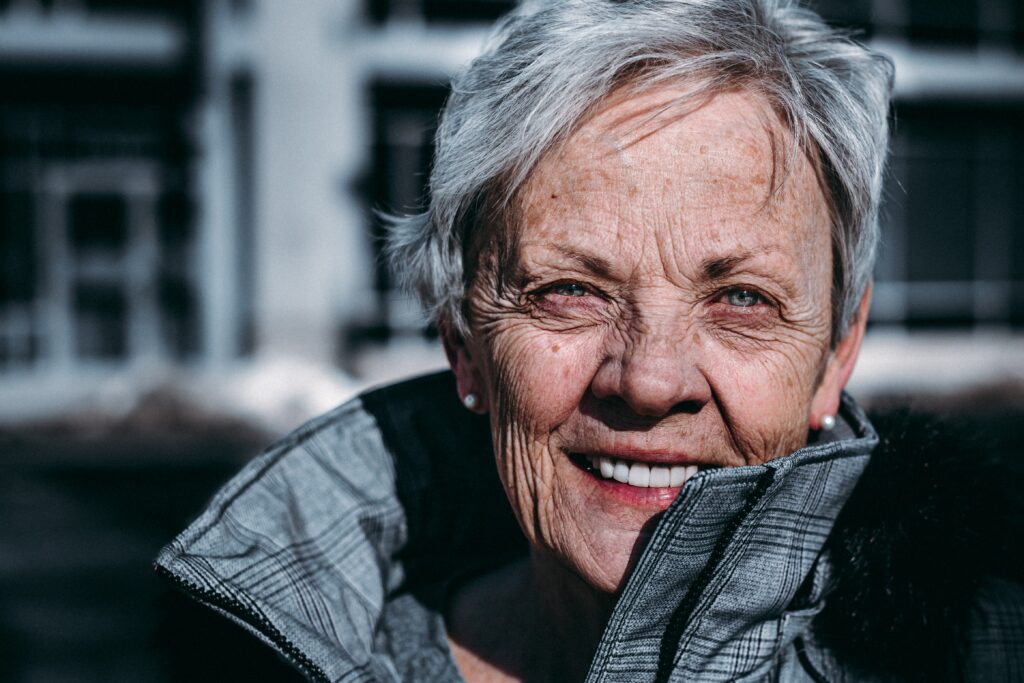 a woman smiling with grey hair