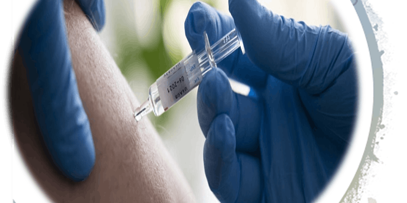 blue gloved hands giving a vaccine shot