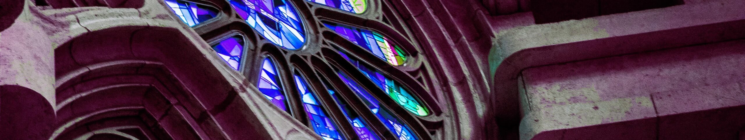 blue stained glass window of a church 650 px high